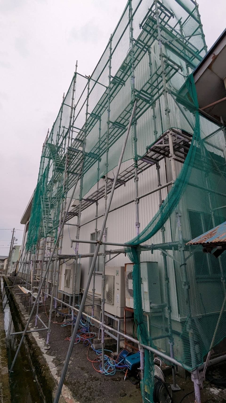 倉庫の外壁改修工事のために足場を設置した様子|富山市塚原